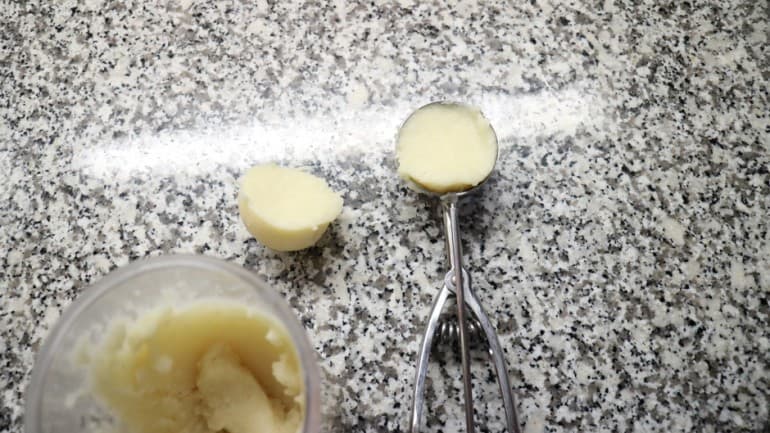 Portion of the raw dumpling dough with an ice-cream scoop.