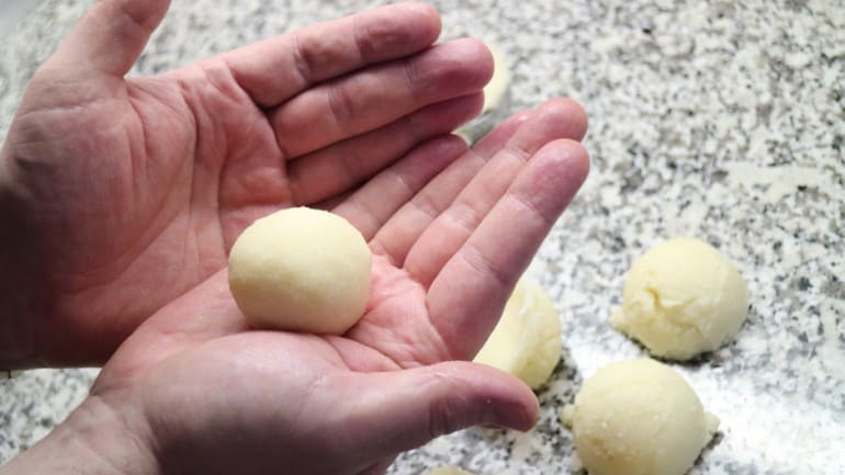 Roll the raw dumpling dough evenly round with wet hands.