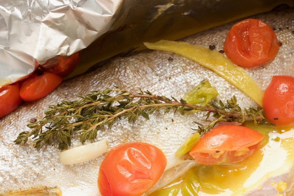 Preparing fish in aluminum foil Recipe Picture Trout in aluminum foil with vegetables and white wine sauce with thyme and tomatoes
