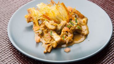 zurich ragout with tomato cubes and roesti on a plate
