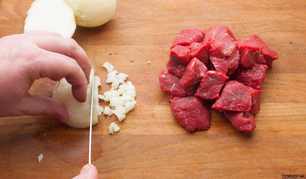 Cut onions for beef goulash.
