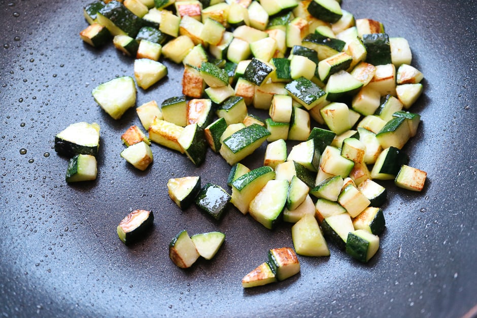 fried zucchini cubes in a pan.