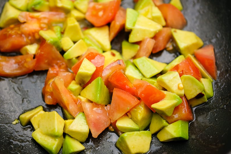 Tomatoes and avocado, diced when marinating with lemon juice and olive oil for couscous.