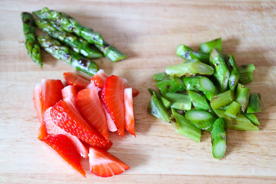 Cut asparagus and strawberries for salad.
