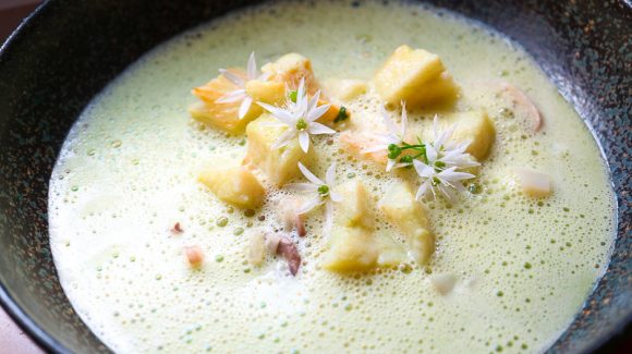 Wild garlic soup with fish and vegetables