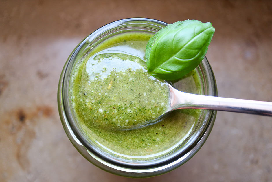 Homemade basil pesto photographed in a glass.