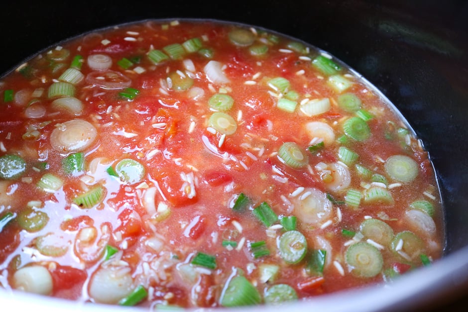 Tomato rice with vegetable broth in a saucepan.