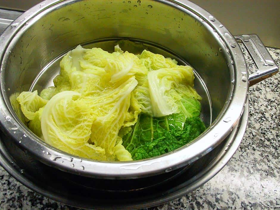 Cooked savoy cabbage leaves in a colander