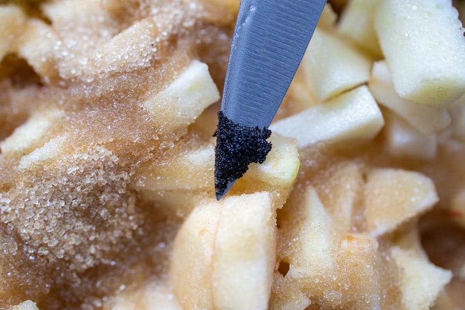 Vanilla pulp with pieces of apple and sugar in the background