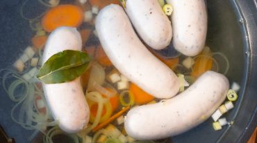 White sausages in the cooking stock