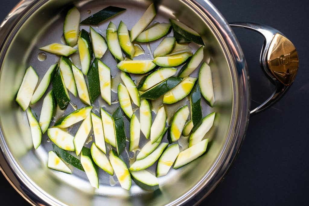 Zucchini with oil in pan
