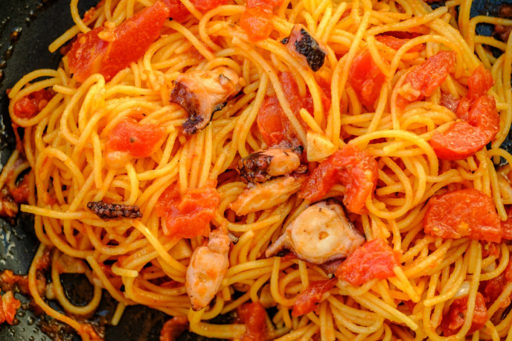 Spaghetti mixed with pulpo and tomato sauce