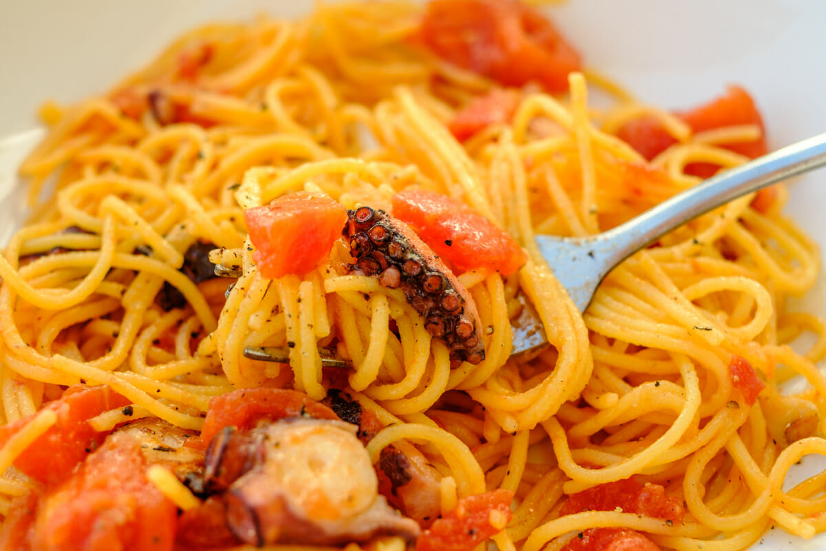 Close-up of spaghetti with tomato sauce and pulpo