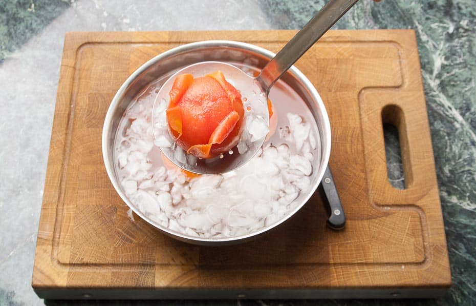 Place the blanched tomatoes from the boiling water into the ice water.