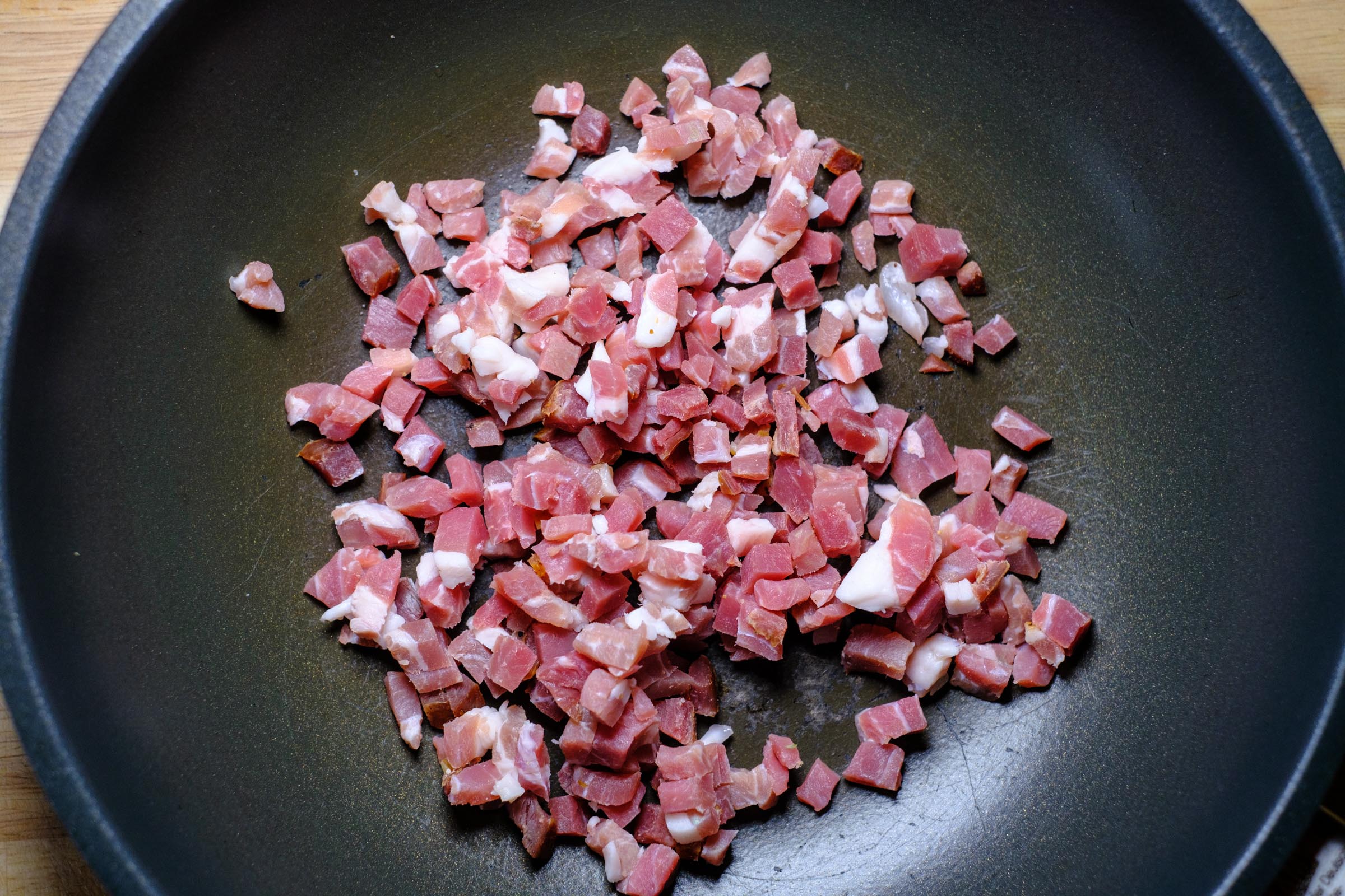 Raw Bacon cubes in pan