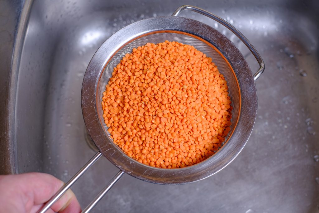 Place red lentils in a sieve