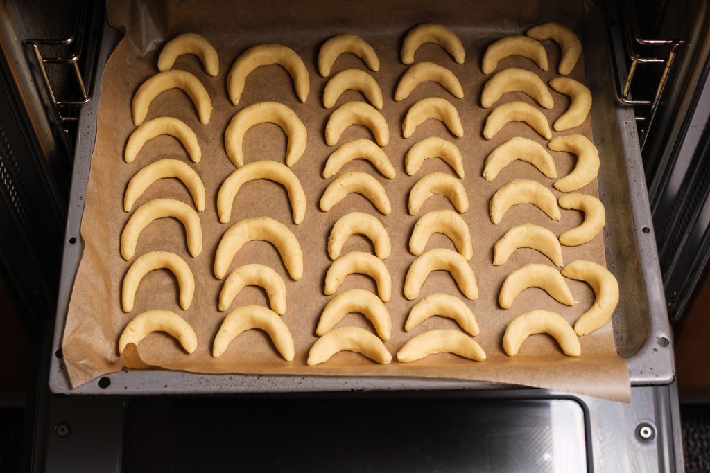 Put the shaped vanilla crescents on the baking tray in the oven