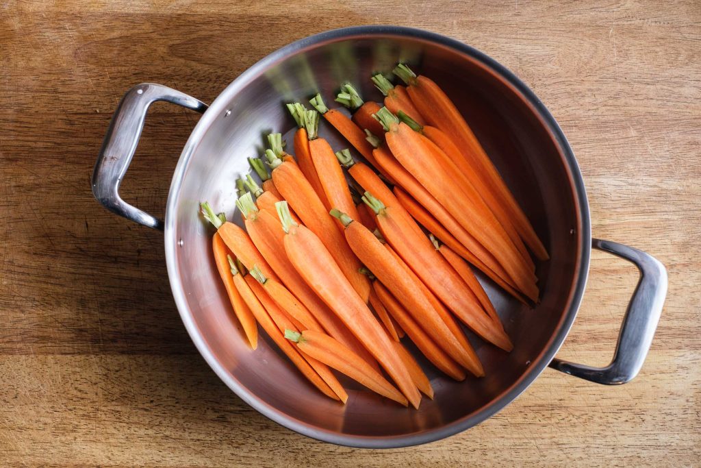 Carrots with greens in a pot
