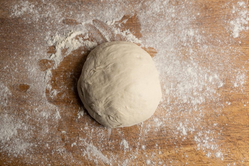 Pizza dough on the board with flour