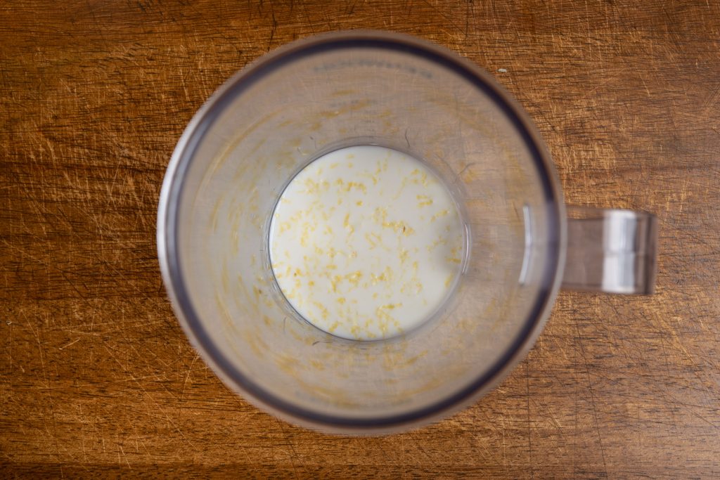 Milk and lemon zest in blender jug